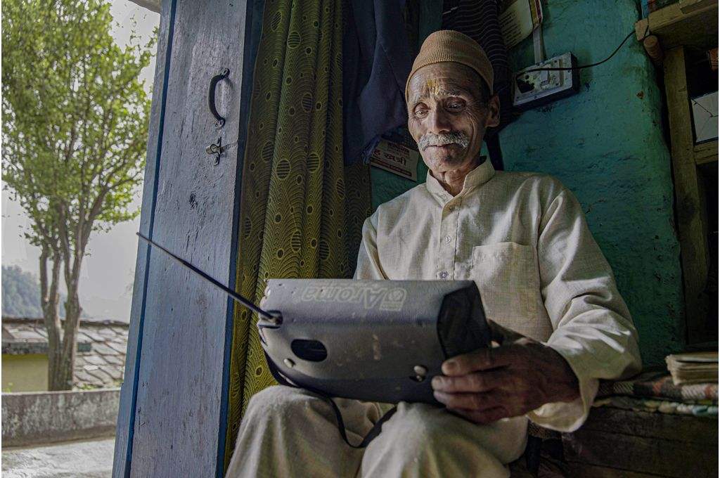 उत्तराखंड के रुद्रप्रयाग जिले के एक सेवानिवृत्त स्कूल शिक्षक योगंबर सिंह रावत ने सामुदायिक रेडियो स्टेशन की धुन बजाई-जलवायु परिवर्तन