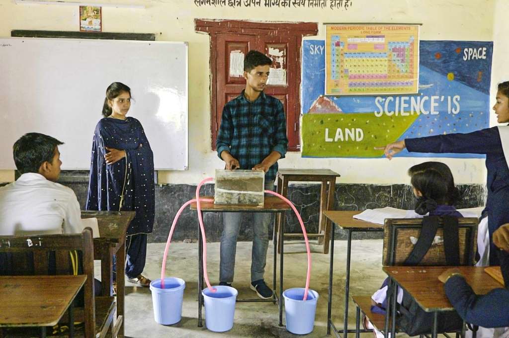 हीरा और चंदन उत्तराखंड में नैनीताल जिले के सुदा गांव में स्कूली छात्रों को जल संरक्षण और वसंत पुनर्भरण तकनीक के बारे में बताते हुए -जलवायु परिवर्तन