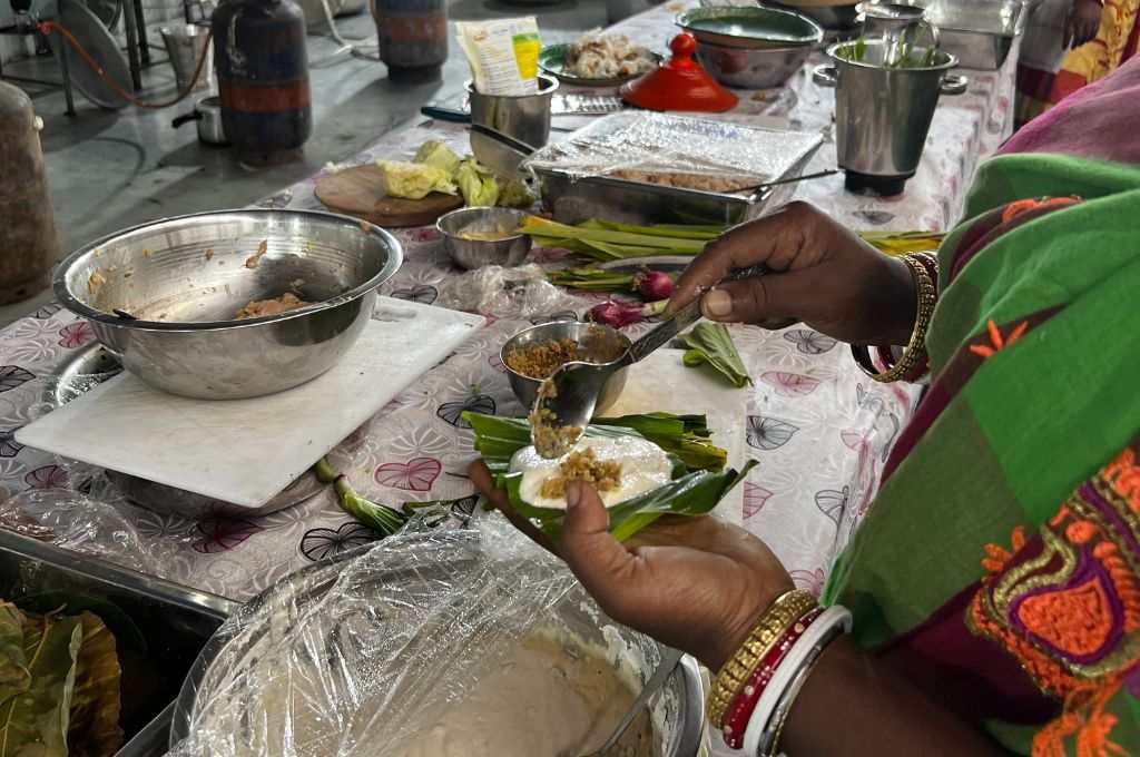 सामुदायिक किचन में खाना बनाती महिला_आदिवासी खाना