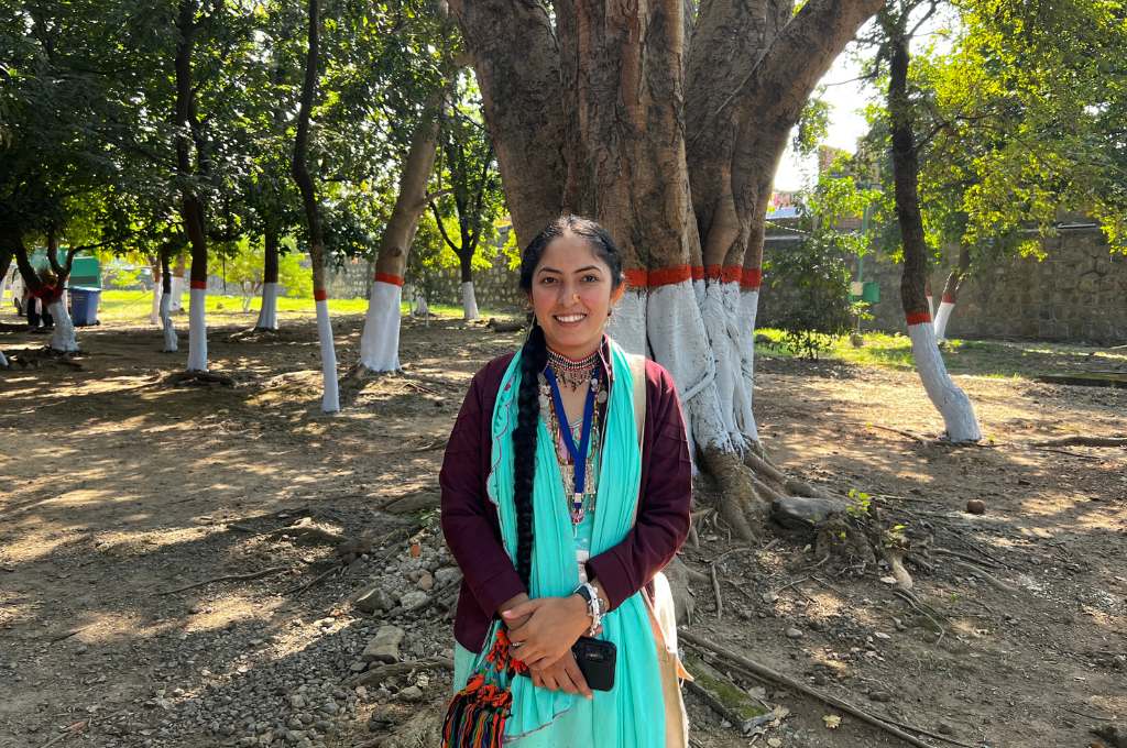 बरगद के पेड़ के सामने खड़ी महिला-आदिवासी महिला नेता