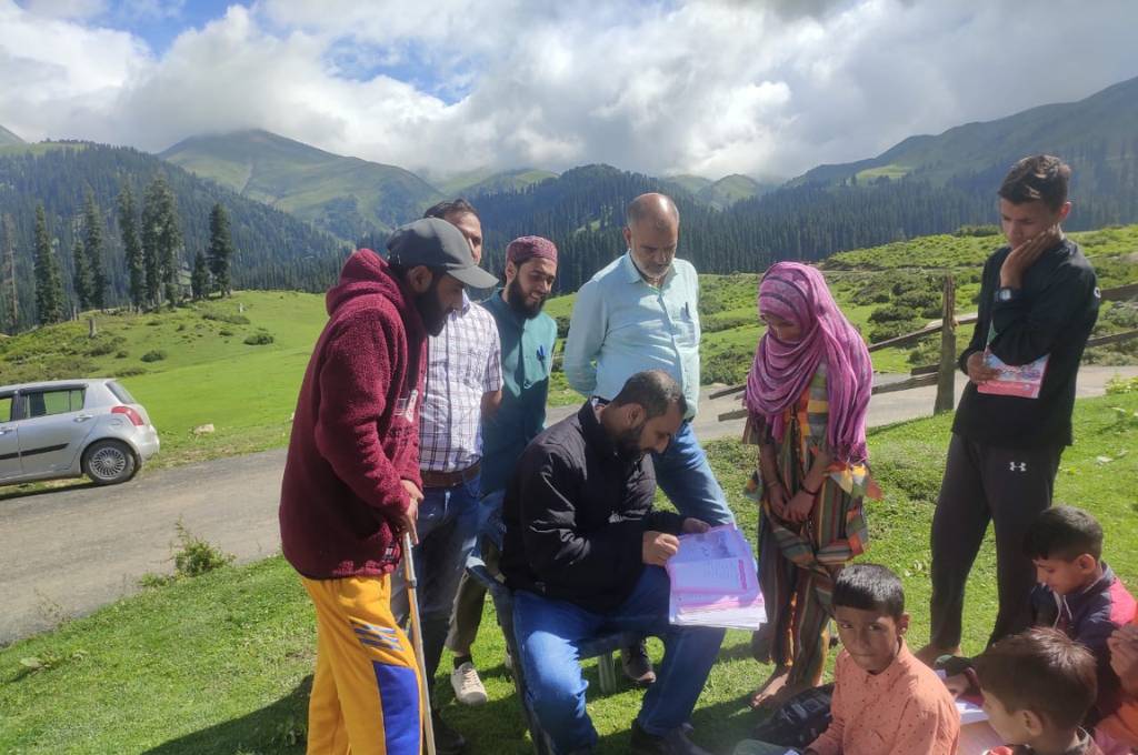एक शिक्षक के चारों ओर छात्रों का एक समूह-कश्मीर शिक्षा