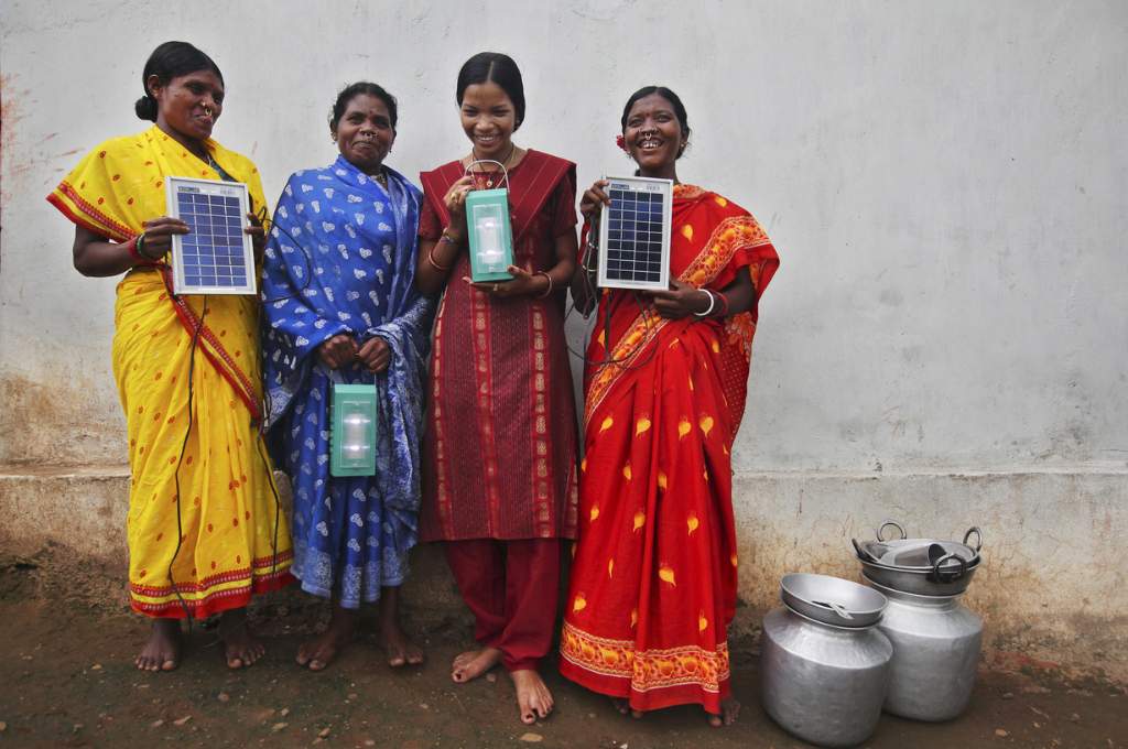 अपने हाथ में सोलर पैनल लेकर खड़ी चार महिलाएं_महिला जलवायु परिवर्तन
