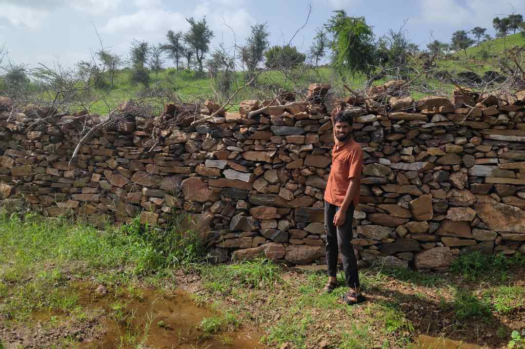 पत्थर की दीवार से लगे खड़ा एक युवा_सार्वजनिक भूमि संरक्षण