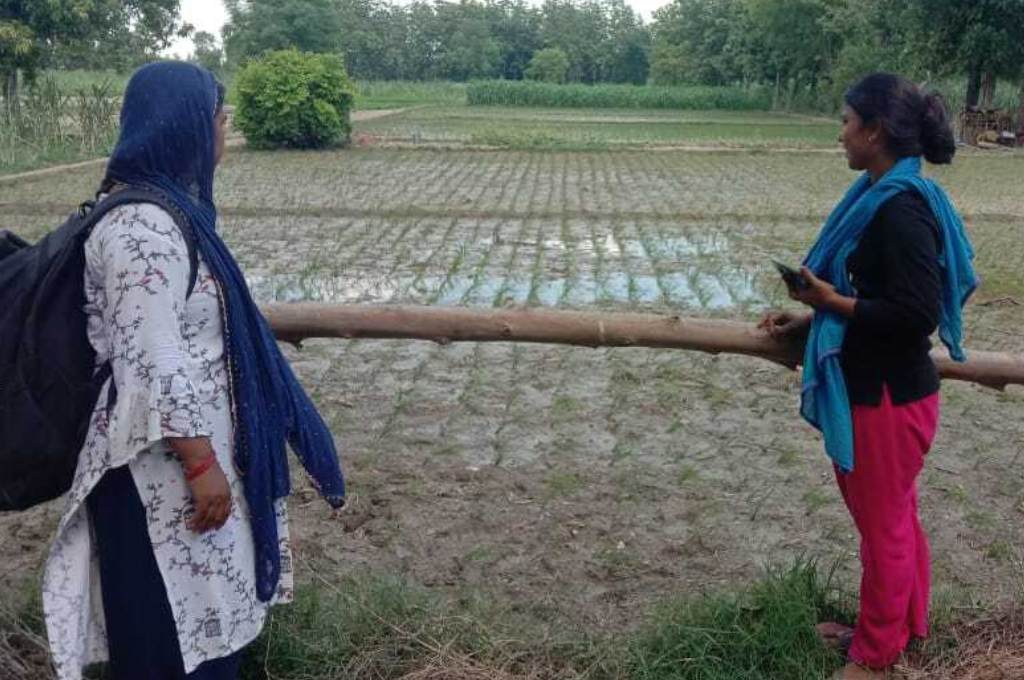 खेत में खड़े होकर बात करती दो महिलाएं_ग्रामीण कामकाजी महिला