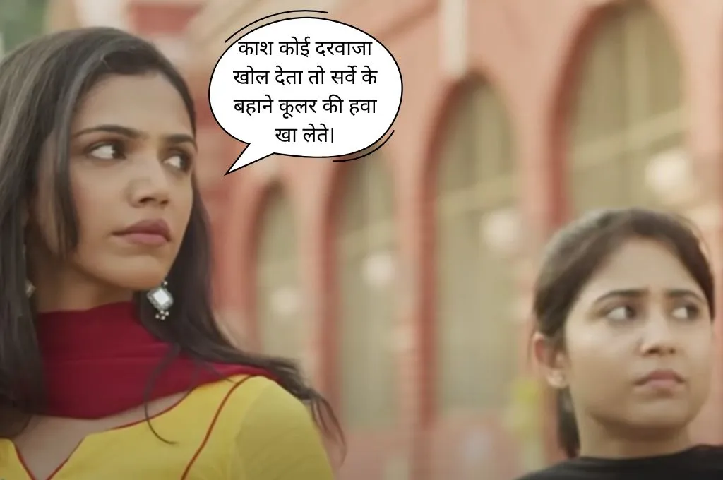 दो महिलाएं किसी बिल्डिंग के आगे खड़ी हैं, एक पीली सलवार-कमीज़ में महिला उदासी से बाईं ओर देख रही है और दूसरी महिला चिंतित चेहरों के साथ दाईं ओर देख रही है। ऊपर डायलाग बॉक्स में लिखा है: "काश कोई दरवाजा खोल देता तो सर्वे के बहाने कूलर की हवा खा लेते"_फील्ड ट्रिप