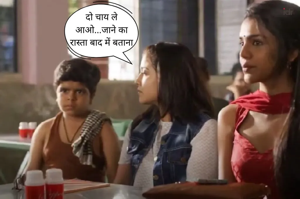एक चाय की दुकान पर तीन लोग बैठे हैं—एक छोटा लड़का गमछा डाले हुए, और दो लड़कियां जिनमें से एक लाल सूट में है। लड़का गुस्से में दिख रहा है और एक डायलाग बॉक्स में लिखा है: 'दो चाय ले आओ... जाने का रास्ता बाद में बताना"_फील्ड ट्रिप