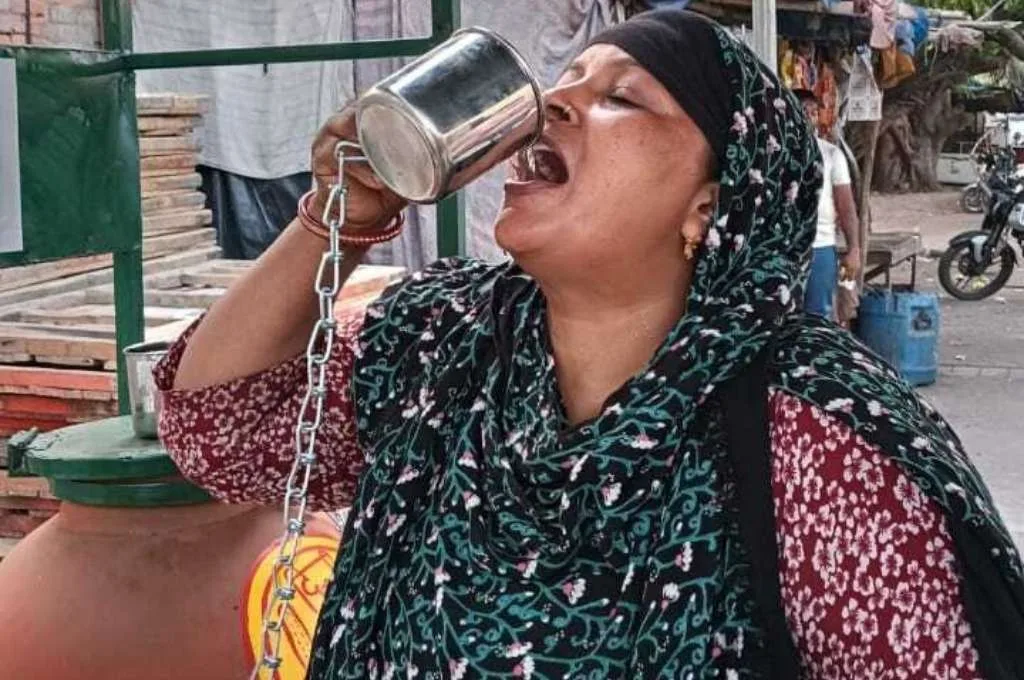 मग से पानी पीती एक महिला_पानी