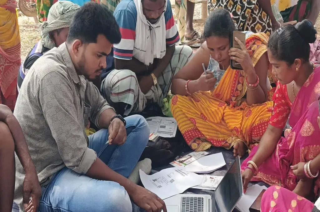 लोगों के आधार कार्ड से केवायसी करता हुआ व्यक्ति_ई-केवायसी
