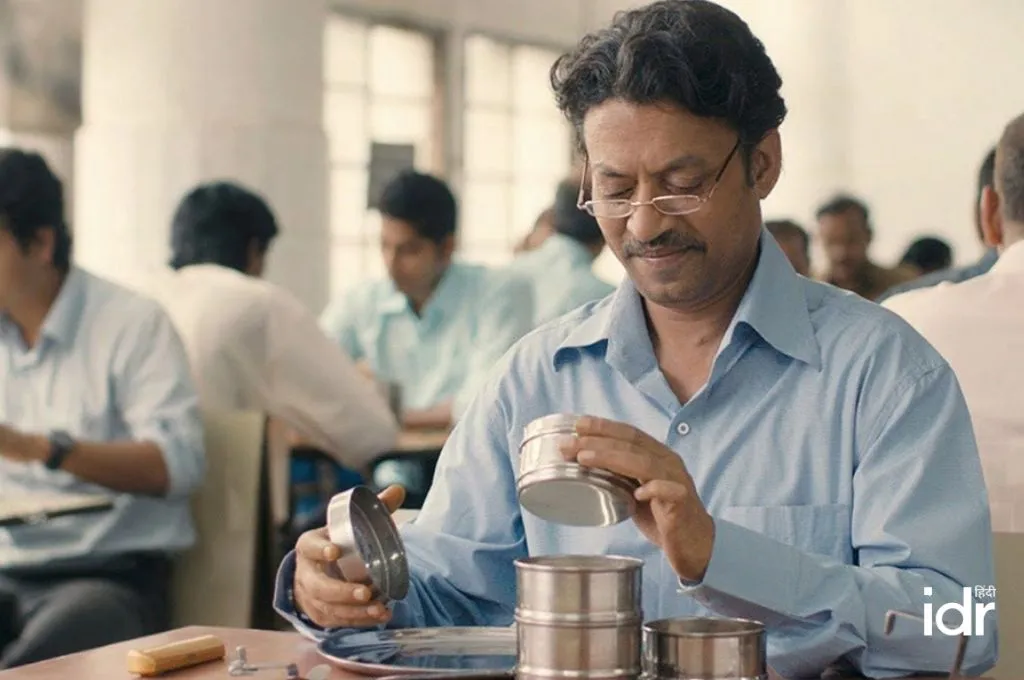 कैंटीन में खाना खाते पुरुषों के बीच टिफिन खोलता एक पुरुष_फील्ड ट्रिप बजट