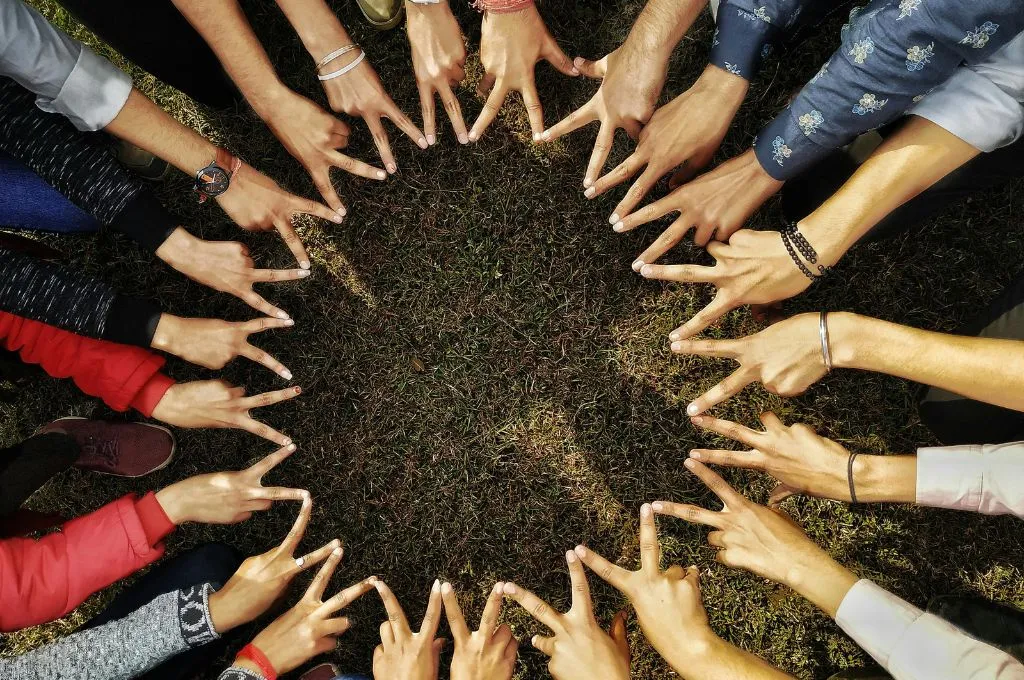 विजय हस्तमुद्रा में जुड़े कई लोगों के हाथ_जमीनी कार्यकर्ता