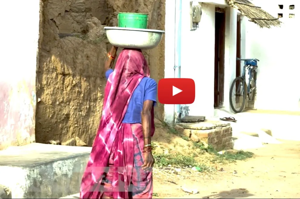 सिर पर पानी ढोकर जाती एक महिला_जातिगत भेदभाव