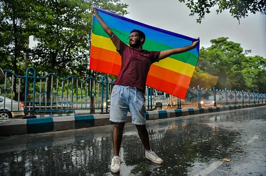 कई रंगों के ध्वज के साथ एक व्यक्ति_ट्रांस संशोधन विधेयक