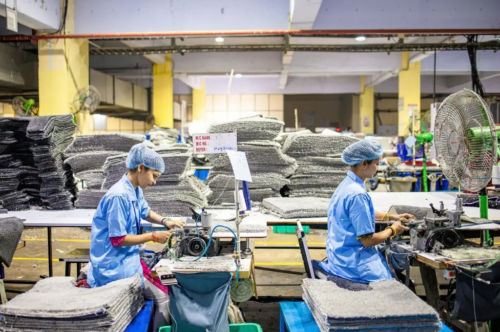 सिलाई मशीन पर कपड़े सिलती हुई महिला कामगार_कौशल विकास