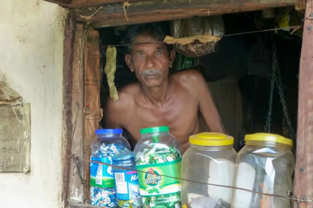 प्लास्टिक के डब्बों के पीछे बैठा एक आदमी_पुस्तकालय