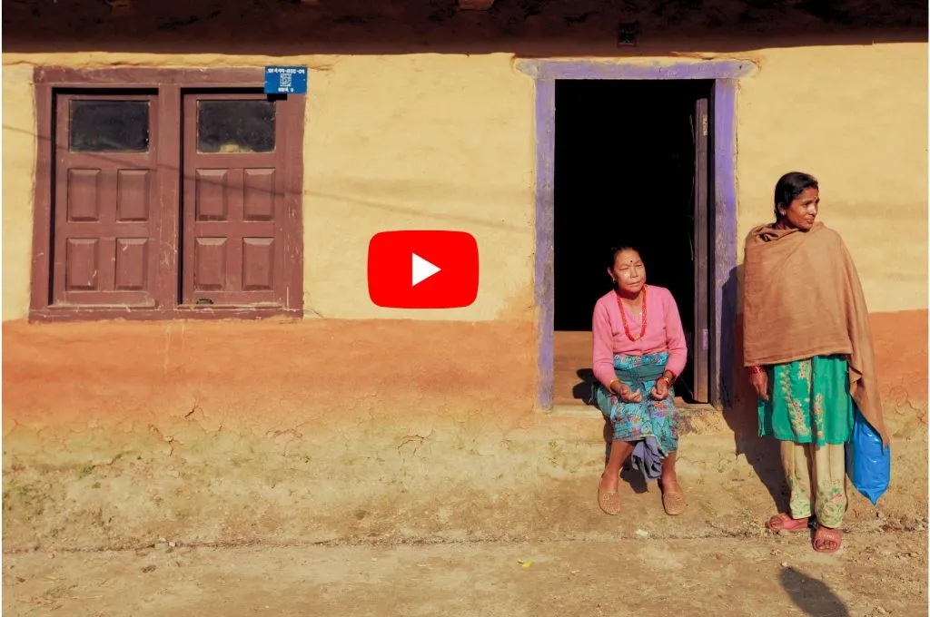 अपने घर के बाहर दरवाज़े पर बैठी एक महिला और खड़ी एक लड़की_पलायन