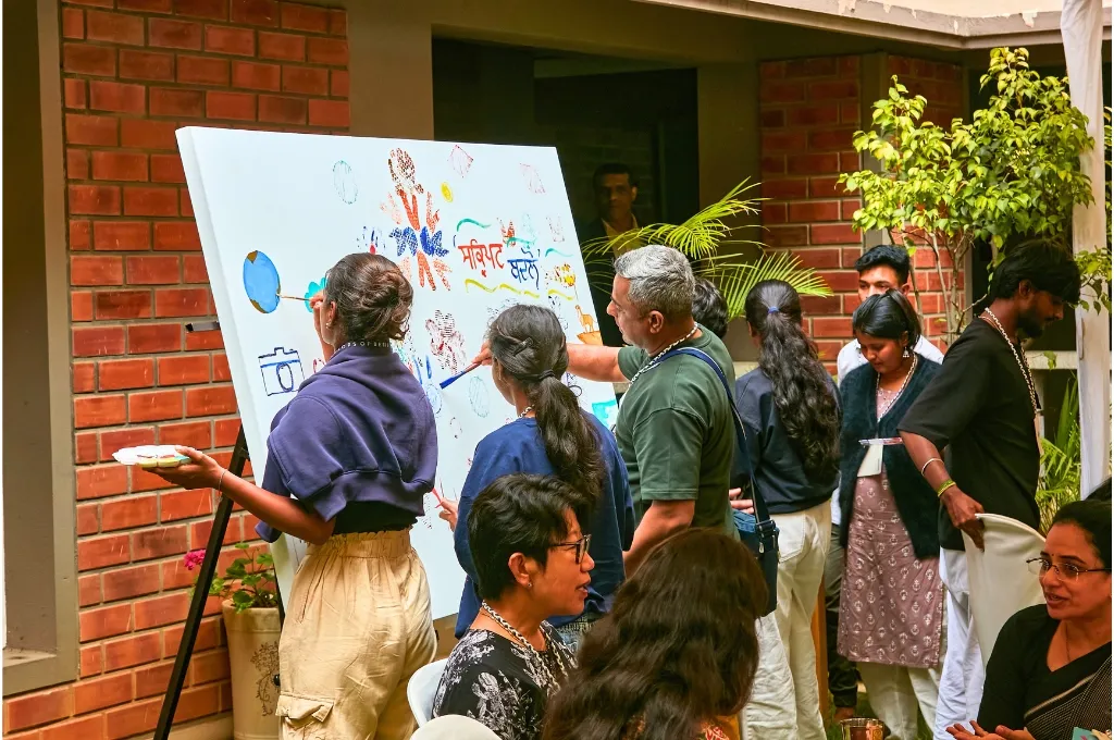 एक कैनवास पर पेंटिंग करते कुछ लोग_थ्राइविंग