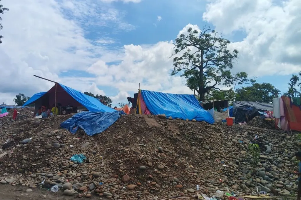 मिट्टी के ढेर पर नीले रंग की प्लास्टिक वाले कुछ तम्बूनुमा आवास_आपदा
